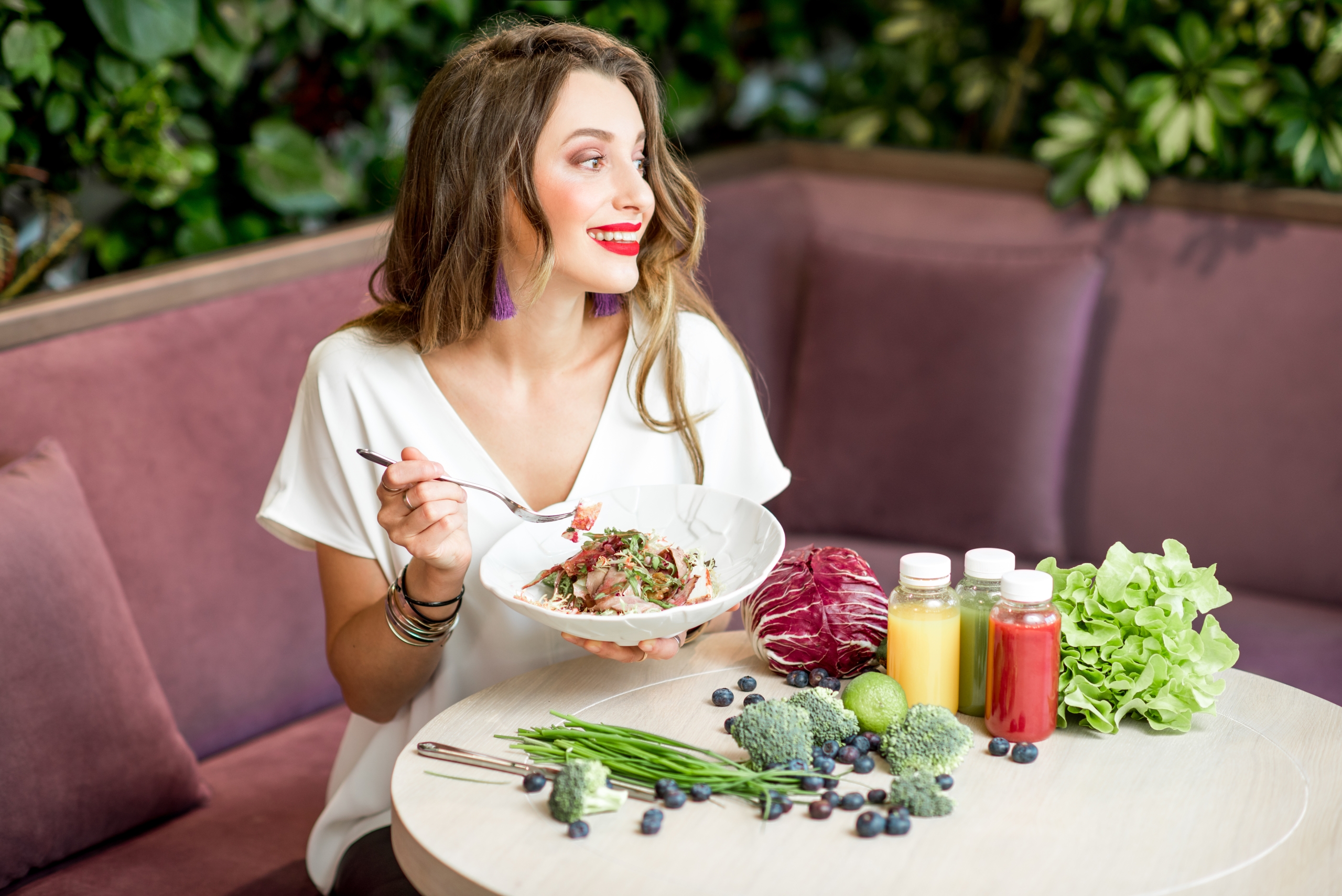 Woman with healthy food on the green wall background
